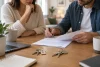 Deux adultes examinent un contrat de location générique avec deux jeux de clés.