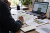 Un investisseur analyse des documents fonciers génériques avec une calculatrice.